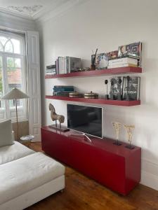 een woonkamer met een rood tv-meubel met een televisie bij Duke`s Retreat in Porto