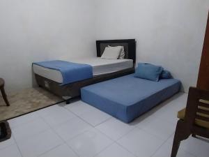 Кровать или кровати в номере Homestay larangga