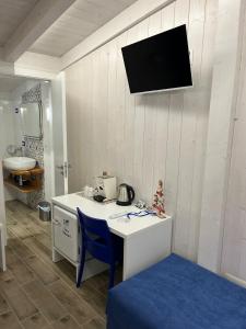 斯卡莱阿B&B Santorini的客房设有书桌、水槽和墙上的电视。