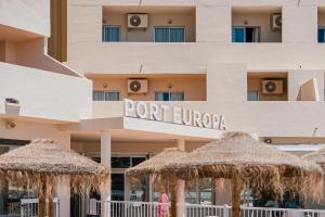 a hotel with straw umbrellas in front of it at Port Europa in Calpe