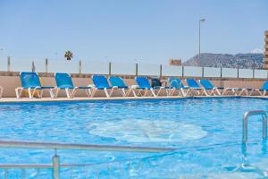 a row of blue chairs in a swimming pool at Port Europa in Calpe