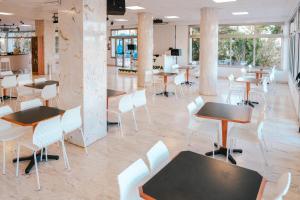 a restaurant with tables and white chairs and tables at Port Europa in Calpe