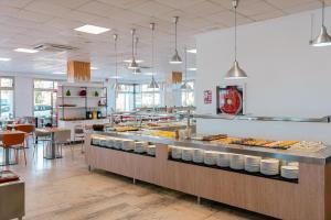 a restaurant with a counter with food on it at Port Europa in Calpe