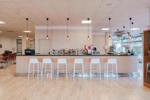a bar in a restaurant with white stools at Port Europa in Calpe