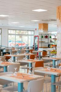 an empty restaurant with tables and chairs and windows at Port Europa in Calpe