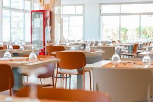 a dining room with tables and chairs and windows at Port Europa in Calpe