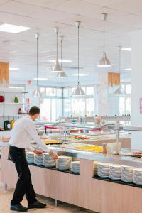 a man standing in a kitchen preparing food at Port Europa in Calpe