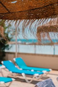 a group of blue lounge chairs on a beach at Port Europa in Calpe