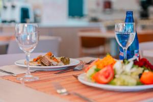 a table with two plates of food and two glasses of wine at Port Europa in Calpe