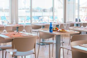 a restaurant with tables and chairs with food on them at Port Europa in Calpe