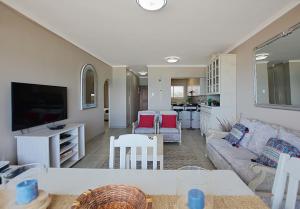 a living room with a couch and a tv at Beach Daze in Bloubergstrand