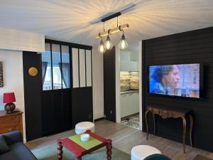 a living room with a flat screen tv on a wall at Loft HATISAS in Brides-les-Bains