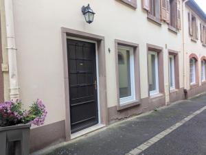 a building with a black door on a street at L'Atelier des Rêves in Saverne