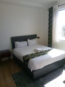 a bed sitting in a bedroom with a window at The Heart of Urban in Nairobi