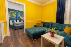 - un salon avec un canapé vert et des murs jaunes dans l'établissement Lambrina Boutique rooms, à Plovdiv