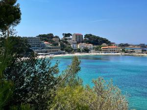 a view of a beach with buildings and the ocean at Villa Ischia Vue Mer in Bandol
