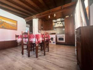 a kitchen with a table with a red table cloth at L'Orchidea in Sante Marie