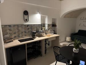 eine Küche mit Theke und einem Tisch mit Stühlen in der Unterkunft Suite Bimbà in Noci