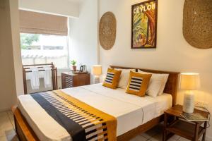A bed or beds in a room at Neevana Hotel Hikkaduwa