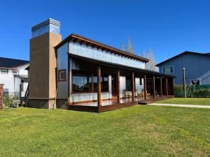 a house with glass doors on a grass field at Patagonia Austral Suites in El Calafate