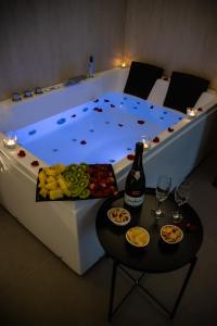 a bed with a table with a bottle of wine and snacks at Real suite spa in Palermo