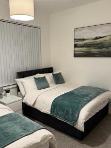 a bedroom with two beds and a painting on the wall at Cozy 3-Bedroom Home Perfect for Work & Leisure in Birmingham