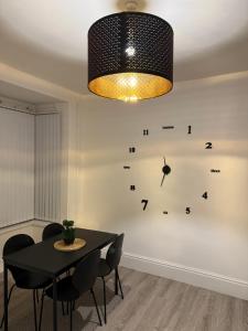 a dining room with a table and a clock on the wall at Cozy 3-Bedroom Home Perfect for Work & Leisure in Birmingham