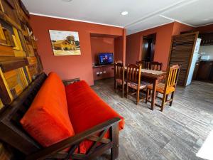 a living room with a couch and a dining room at Patagonia Austral Suites in El Calafate