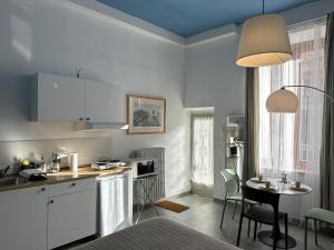 a kitchen with white cabinets and a table with chairs at Nice Studio apartment in Prato
