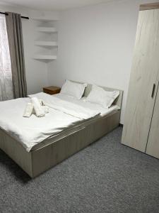 a bed in a room with two shoes on it at Nova Montan Azuga in Azuga