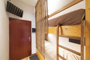 a bedroom with two bunk beds and a door at Ô Cocon - Station de ski à pied vue montagne in Eaux-Bonnes