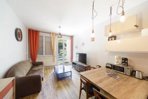 a living room with a couch and a table at Ô Cocon - Station de ski à pied vue montagne in Eaux-Bonnes