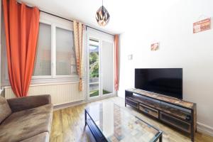 a living room with a couch and a flat screen tv at Ô Cocon - Station de ski à pied vue montagne in Eaux-Bonnes