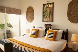 A bed or beds in a room at Neevana Hotel Hikkaduwa