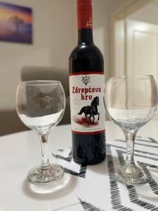eine Flasche Wein neben zwei Gläsern auf dem Tisch in der Unterkunft Apartman Tiki R Vrnjacka Banja in Vrnjačka Banja + 3 Fotos