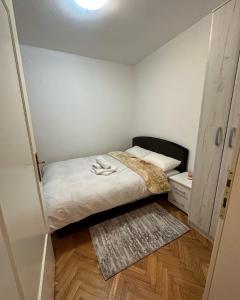 ein kleines Schlafzimmer mit einem Bett und einem Teppich in der Unterkunft Apartman Tiki R Vrnjacka Banja in Vrnjačka Banja