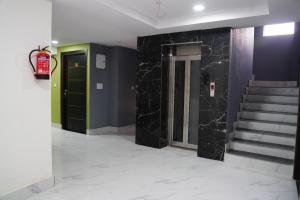 瑞诗凯诗Hotel Aastha Height的一条走廊，墙壁和楼梯都铺着黑色大理石。