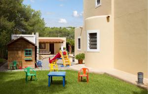 a yard with colorful chairs and a playground at Villa El Abuelo in Santa Eularia des Riu