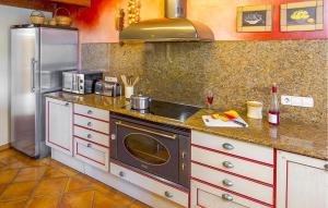 a kitchen with a stove and a sink and a refrigerator at Villa El Abuelo in Santa Eularia des Riu