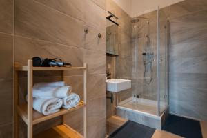 a bathroom with a shower and a sink and towels at New Favoriten - Serviced Apartments in Vienna +44 photos