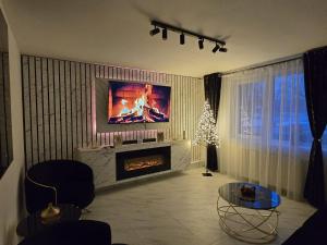 a living room with a fireplace and a christmas tree at AIM & Residence in Piteşti