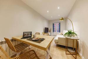 una sala de estar con una mesa y un sofá en Bravissimo Apartaments Mora 4, en Girona