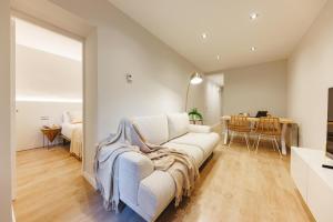 Una sala de estar con un sofá blanco y una mesa. en Bravissimo Apartaments Mora 4, en Girona