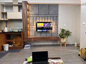 a living room with a tv on a wall at Căn Hộ Hướng Biển Xem pháo hoa gần Vincom,Bảo Tàng Quảng Ninh in Ha Long