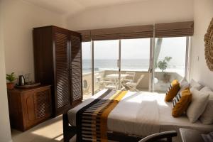 A bed or beds in a room at Neevana Hotel Hikkaduwa