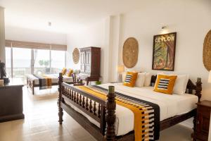 A bed or beds in a room at Neevana Hotel Hikkaduwa