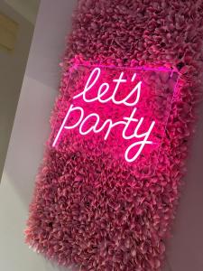 a neon sign that says let party on a pink wall at The PADhouse in York +55 photos
