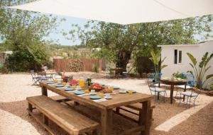 a wooden table with food on it under a white umbrella at Villa Pranayama in Santa Gertrudis de Fruitera