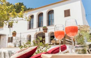 two glasses of wine on a table in front of a building at Villa Pranayama in Santa Gertrudis de Fruitera