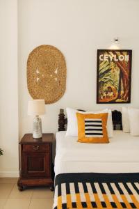 A bed or beds in a room at Neevana Hotel Hikkaduwa
